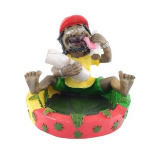 Cendrier design Bob Marley langue tirée en résine, couleurs rasta et feuilles de cannabis.