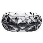 Cendrier en verre noir prismatique, design élégant à facettes géométriques.